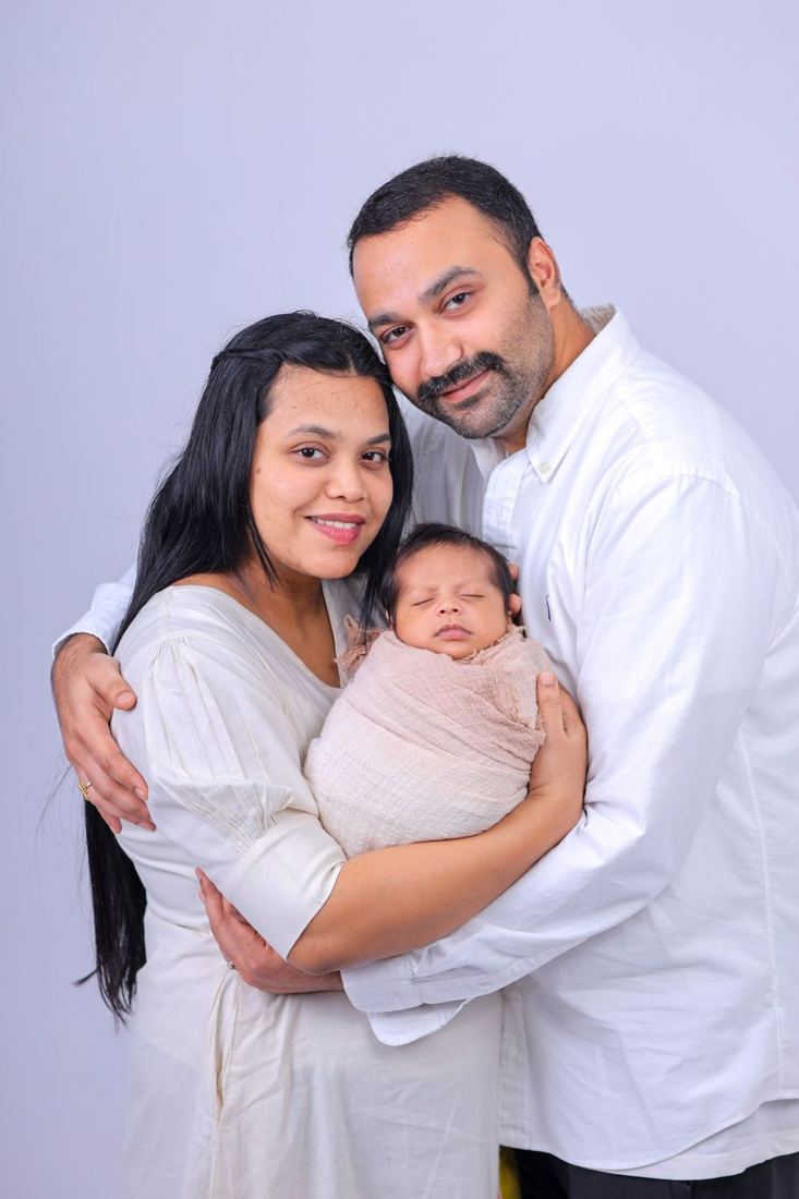 Parents embracing their newborn baby