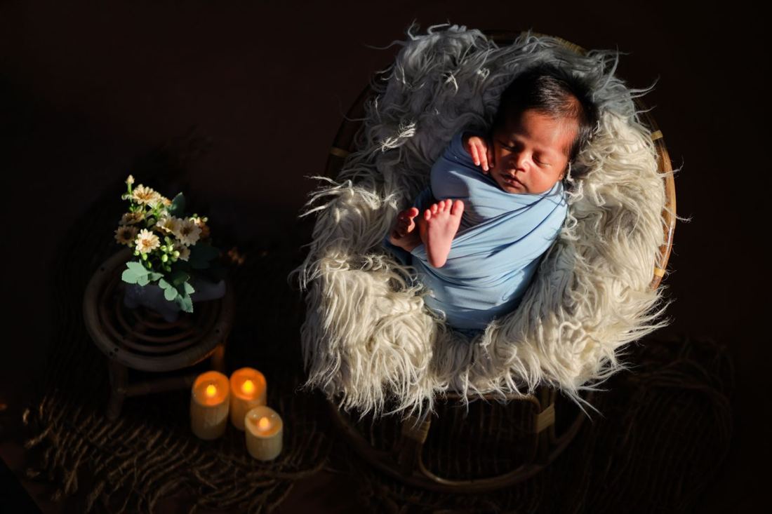 Newborn asleep in a flower nest